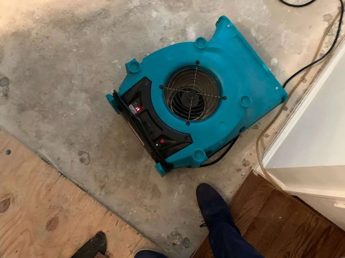 Air mover drying subfloor during Commercial Water Damage Restoration in Anamosa